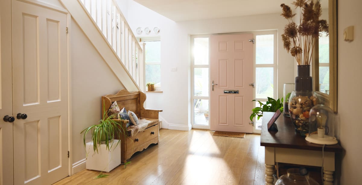 Bright hallway with a pastel front door and white panelled internal doors